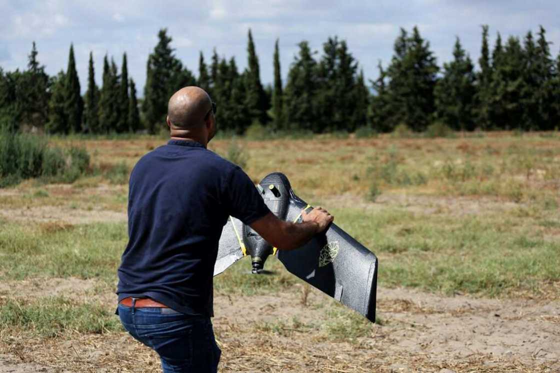 A technician from the RoboCare startup company prepares to fly a drone over an agricultural area A technician from the RoboCare startup company prepares to fly a drone over an agricultural area