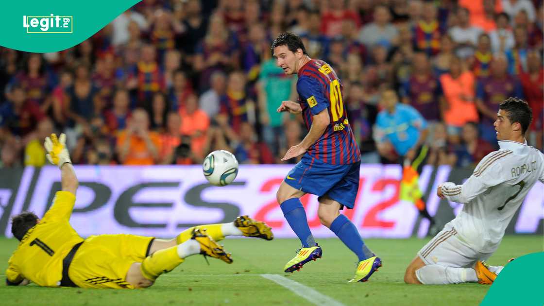 Lionel Messi scores a goal against Iker Casillas and Cristiano Ronaldo in 2011. Photo by LLUIS GENE