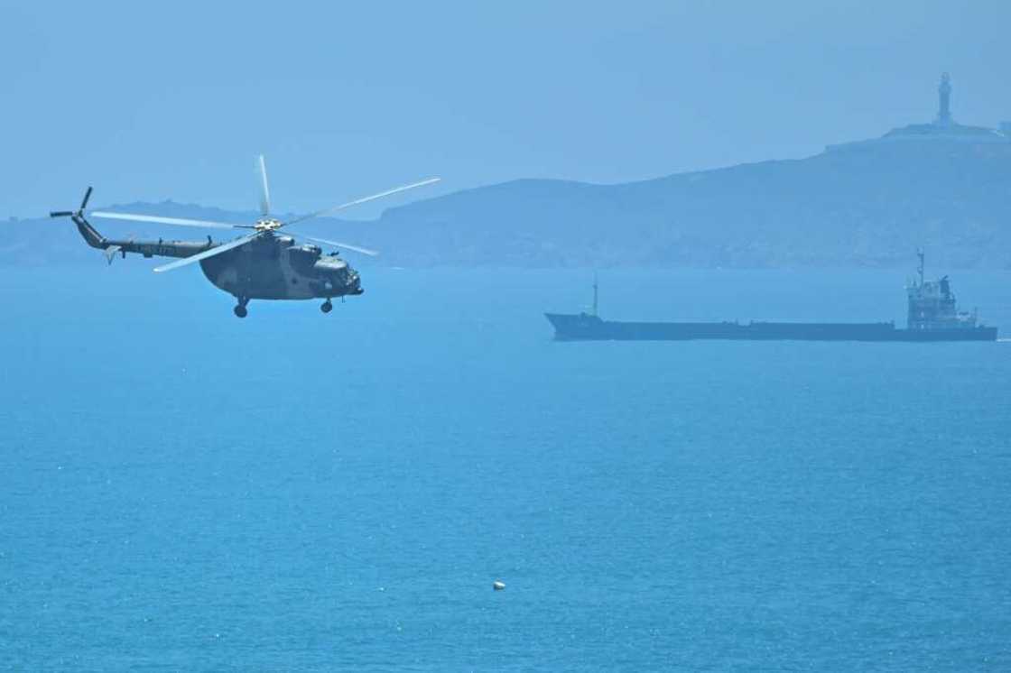 A Chinese military helicopter flies past Pingtan island, one of mainland China's closest points from Taiwan, in Fujian province on August 4, 2022 ahead of massive military drills off Taiwan following US House Speaker Nancy Pelosi's visit