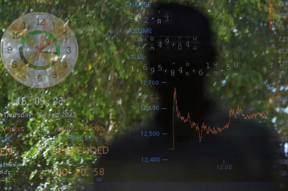 The shadow of a trader is seen against an index board at the Pakistan Stock Exchange in Karachi