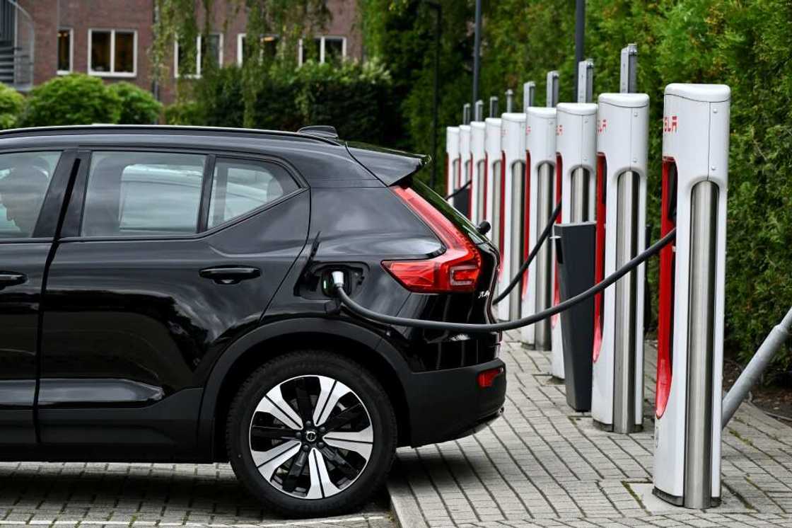 An electric car charges at a charging point reserved for Tesla cars An electric car charges at a charging point reserved for Tesla cars
