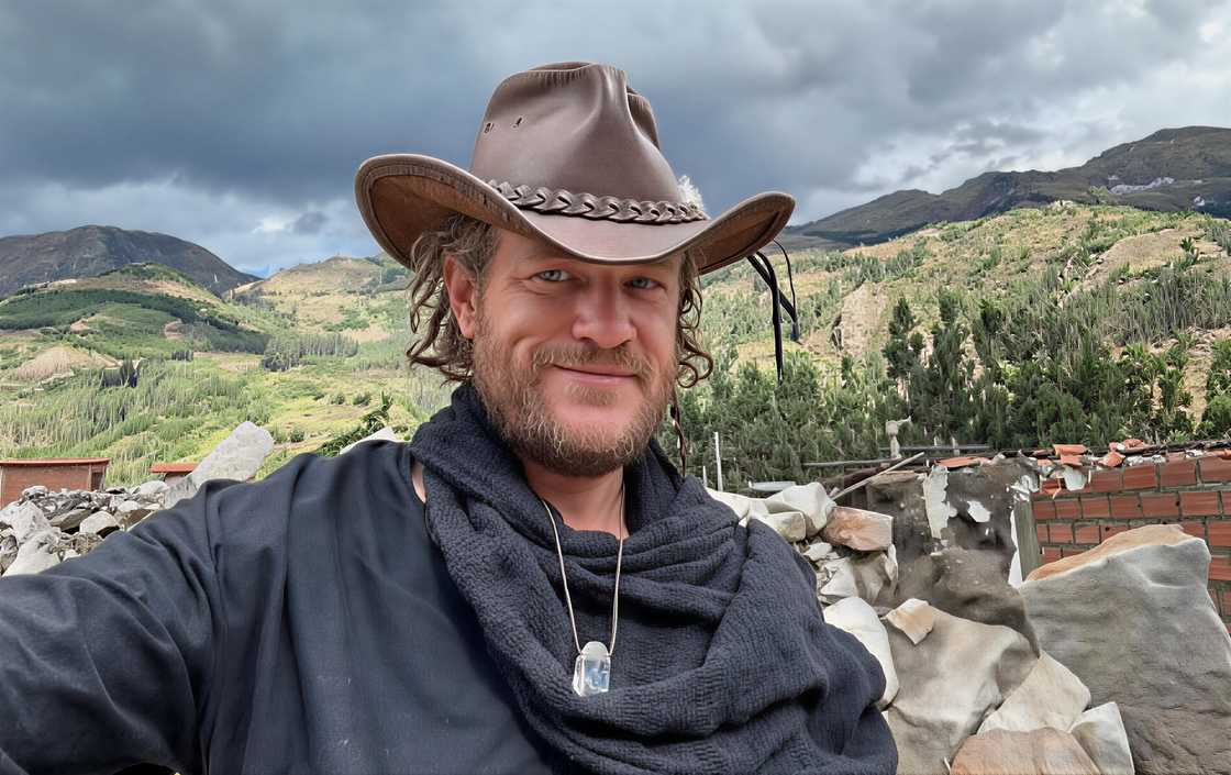 Russell Davis poses in front of a mountain range.