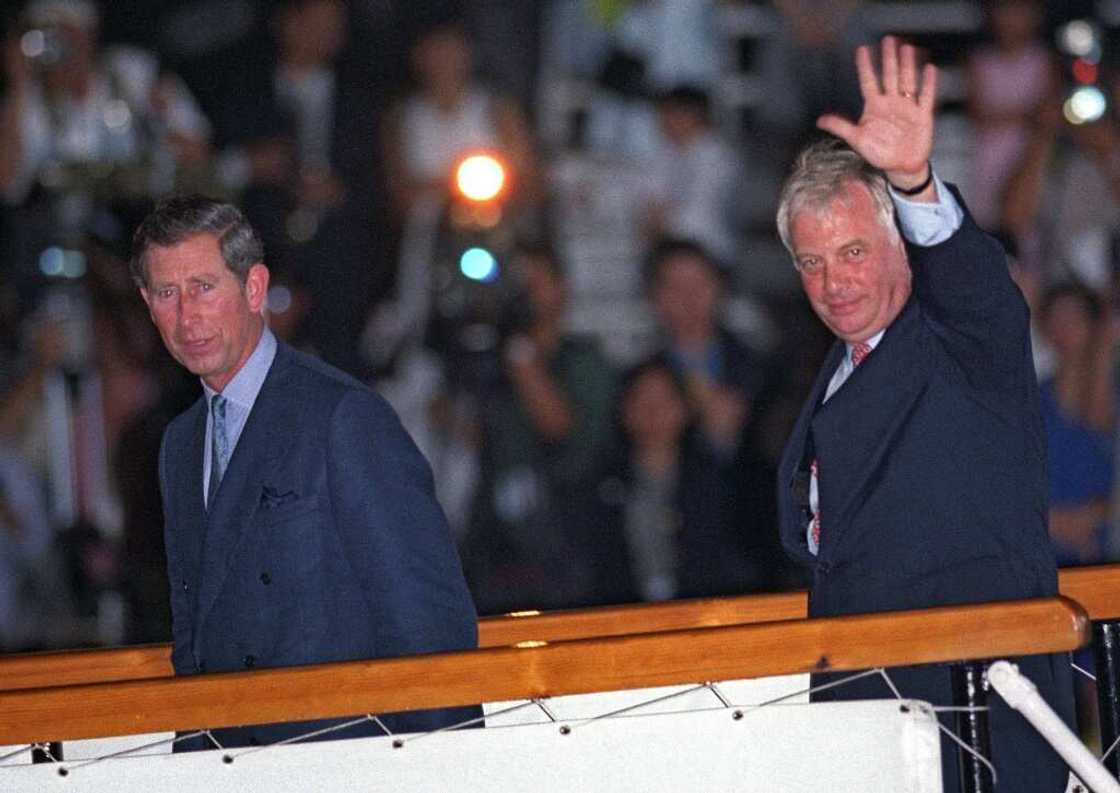 Outgoing Hong Kong governor Chris Patten (R) waves to well-wishers as he boards the Royal Yacht Britannia with Prince Charles on July 1, 1997