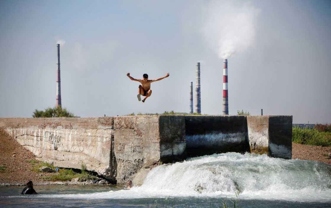 A teenager jumps into the water near the huge Kazakhmys copper plant on the shores of Lake Balkhach in Kazakhstan