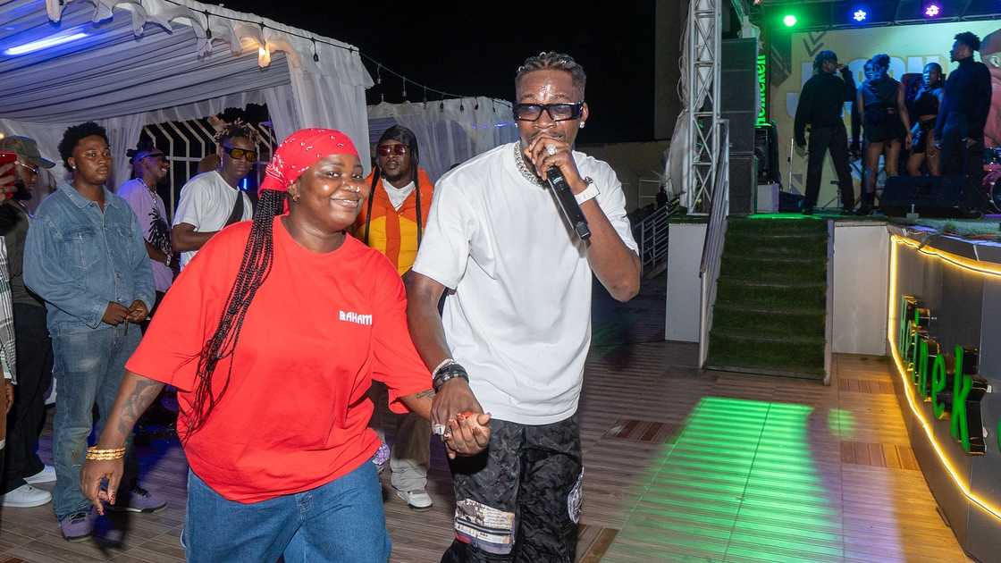 Jason Jae from BBNaija holds a fan's hand as he sings during one of his past performances