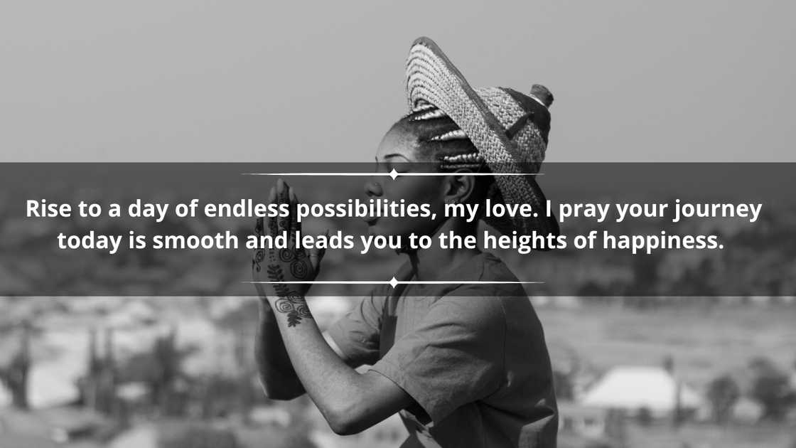 A woman in a hat is praying while sitting on the rocks A woman in a hat is praying while sitting on the rocks