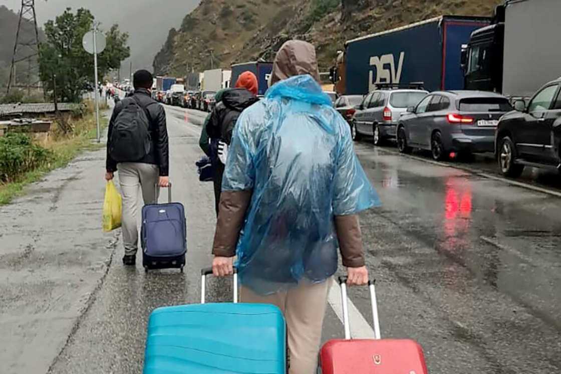 Military-aged Russians have poured into Georgia by cars in a column stretching for some 20 kilometres, by bicycles and some even by foot Military-aged Russians have poured into Georgia by cars in a column stretching for some 20 kilometres, by bicycles and some even by foot