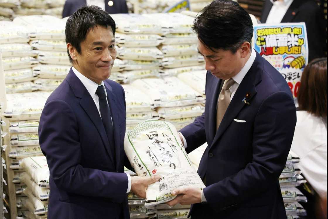 Farm minister Shinjiro Koizumi (R) has pledged to cut rice prices quicker Farm minister Shinjiro Koizumi (R) has pledged to cut rice prices quicker