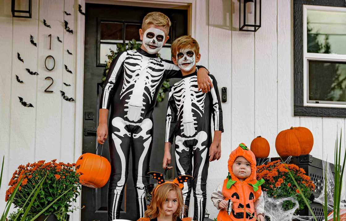 Kids wearing Halloween costume standing on a porch