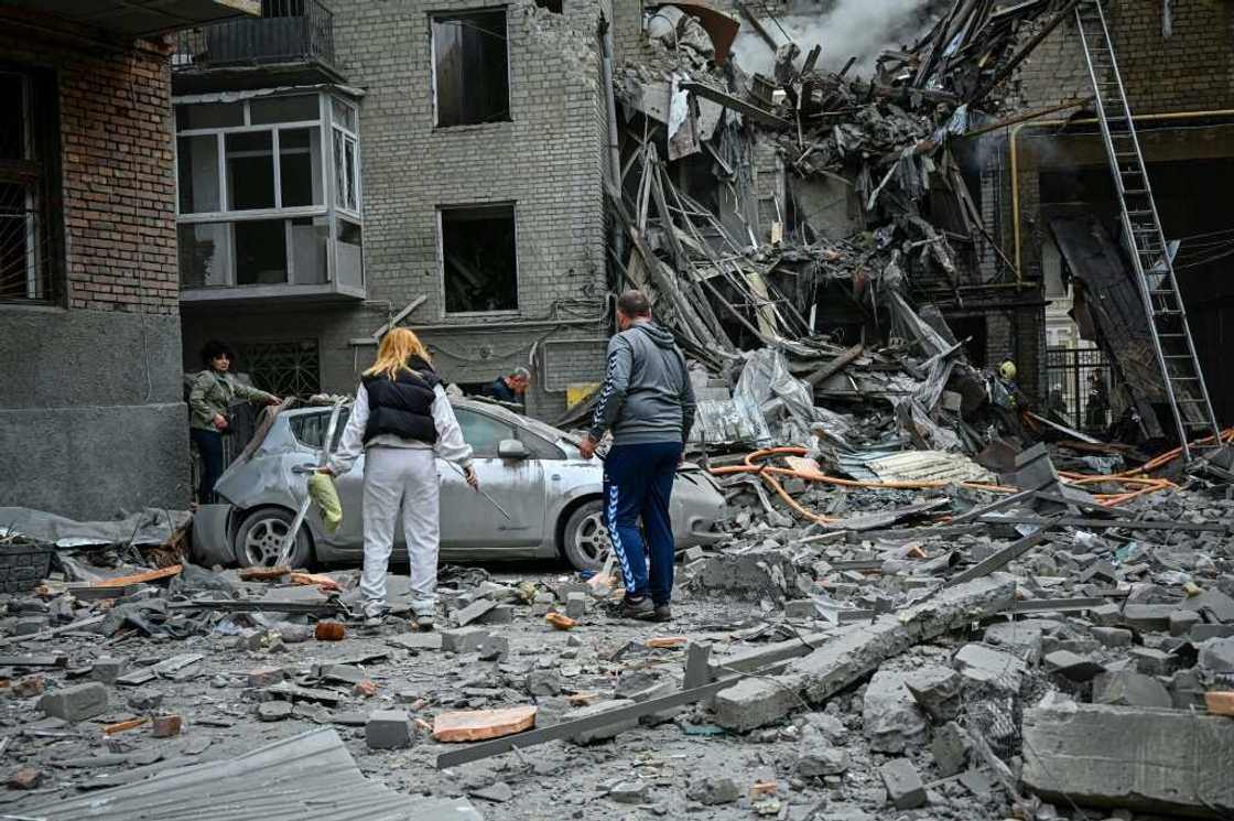 Local residents stand amid the rubble of an apartment after it was hit by a Russian missile strike in Kharkiv, Ukraine. Local residents stand amid the rubble of an apartment after it was hit by a Russian missile strike in Kharkiv, Ukraine.