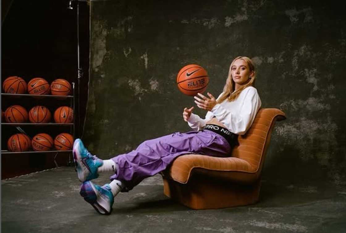 Paige Bueckers posing with balls on a sofa