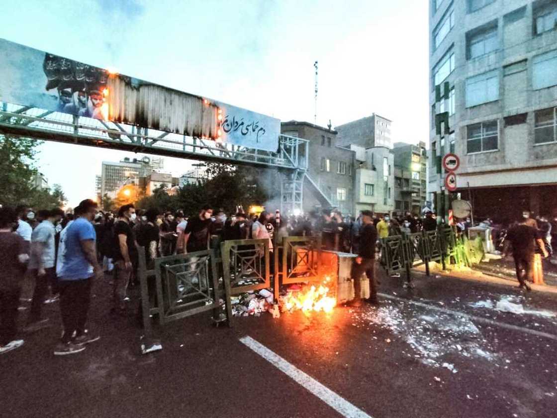 Demonstrators burn a rubbish bin in Tehran