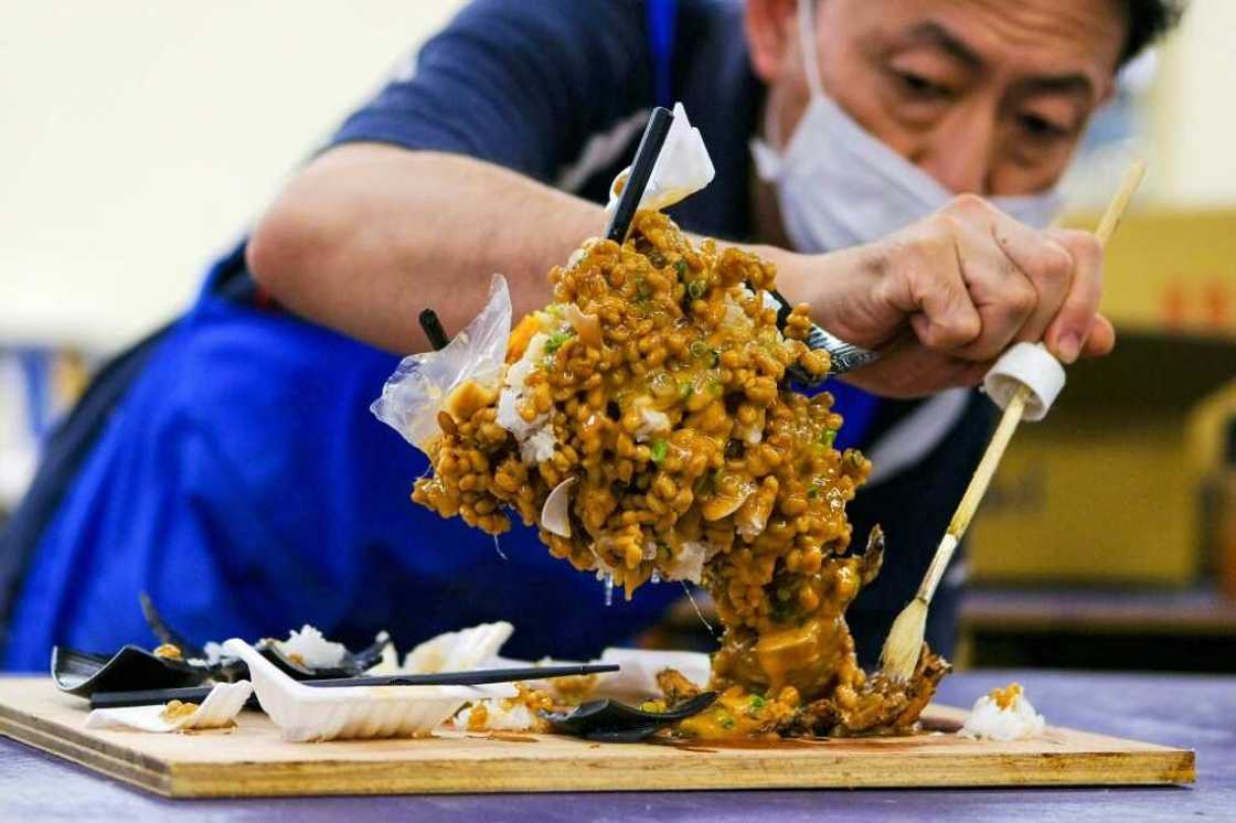A worker applies the finishing touches on his plastic cyclone of fermented soybeans, aka the 'nattornado' A worker applies the finishing touches on his plastic cyclone of fermented soybeans, aka the 'nattornado'