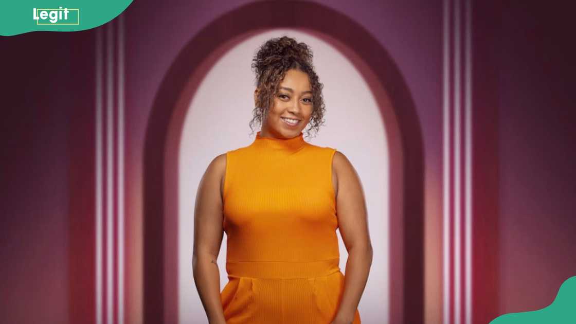 Demi Brown smiling and dressed in an orange sleeveless dress Demi Brown smiling and dressed in an orange sleeveless dress