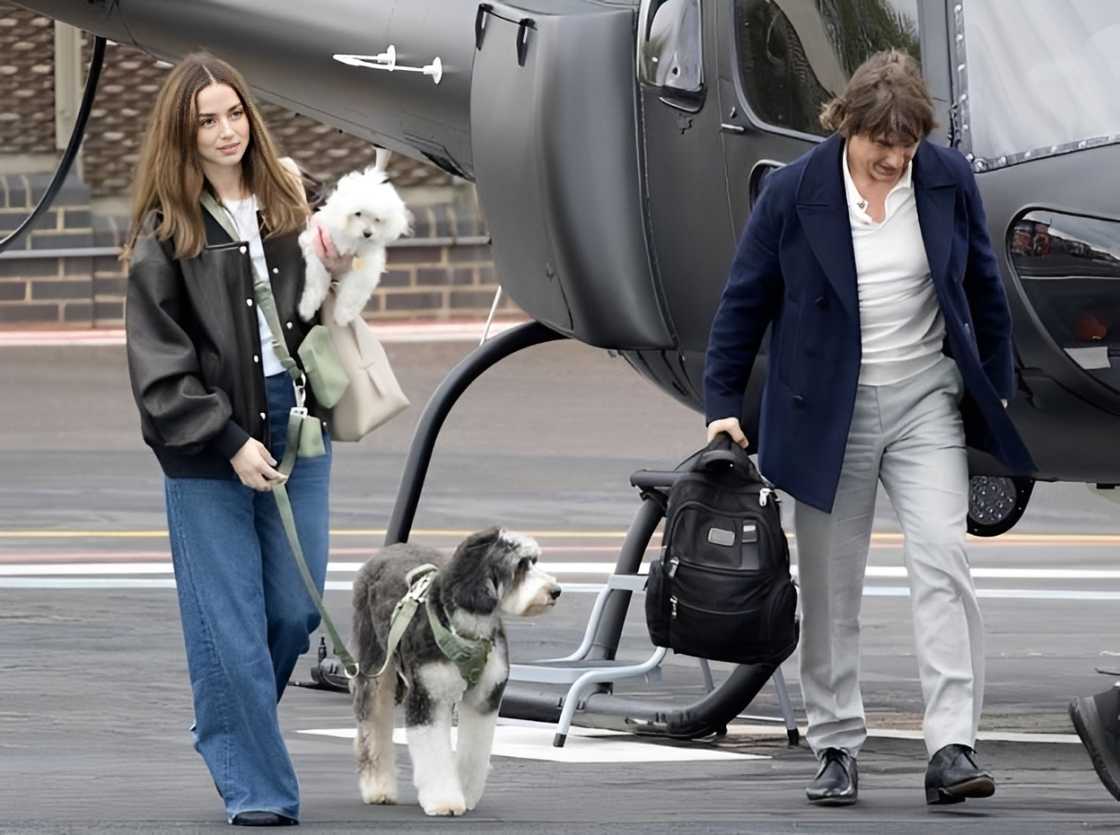 Ana de Armas and Tom Cruise walk away from a helicopter