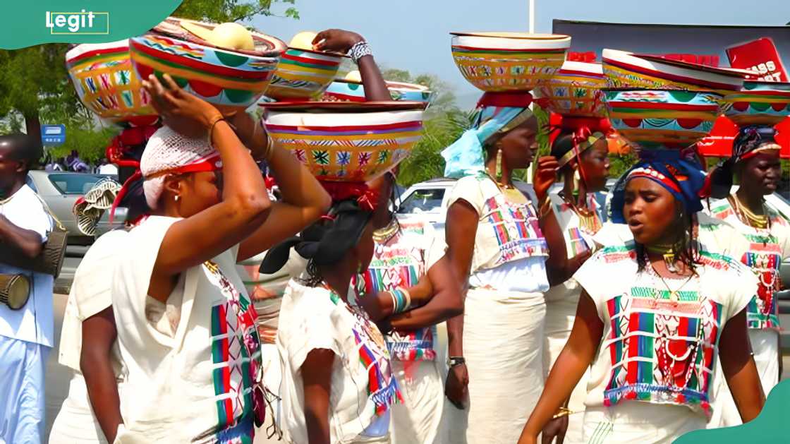 Women dressed in traditional Hausa attire, carrying intricately woven baskets. Women dressed in traditional Hausa attire, carrying intricately woven baskets.