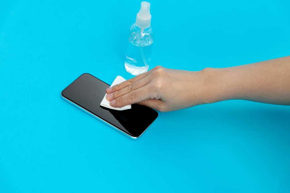 Someone cleaning the back of a phone Someone cleaning the back of a phone