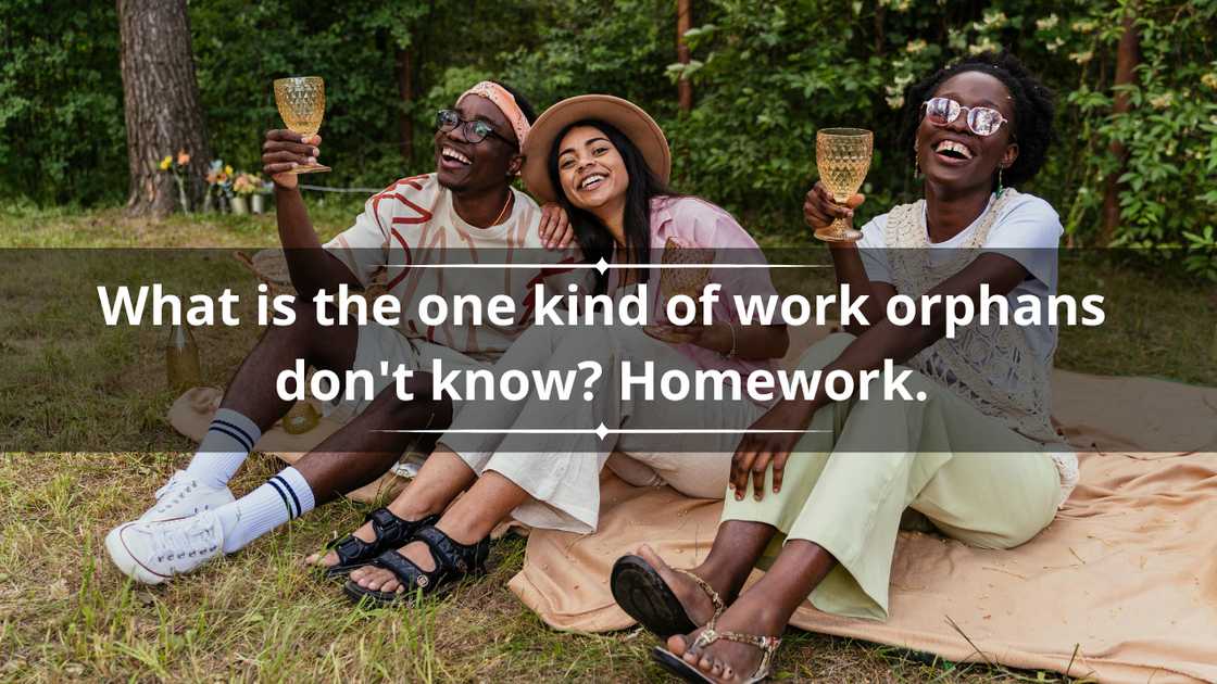 A group of three friends is laughing during a picnic