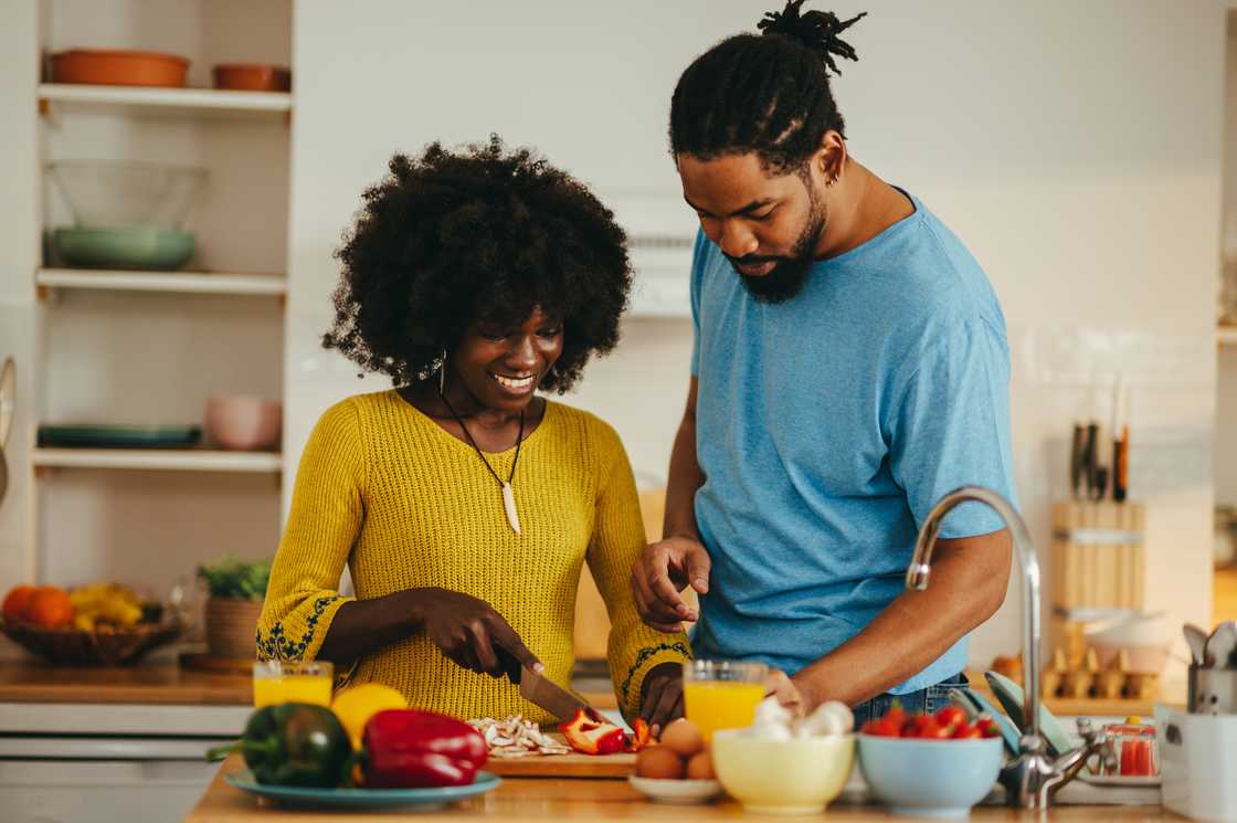 A young couple cooking together in an apartment kitchen. A young couple cooking together in an apartment kitchen.