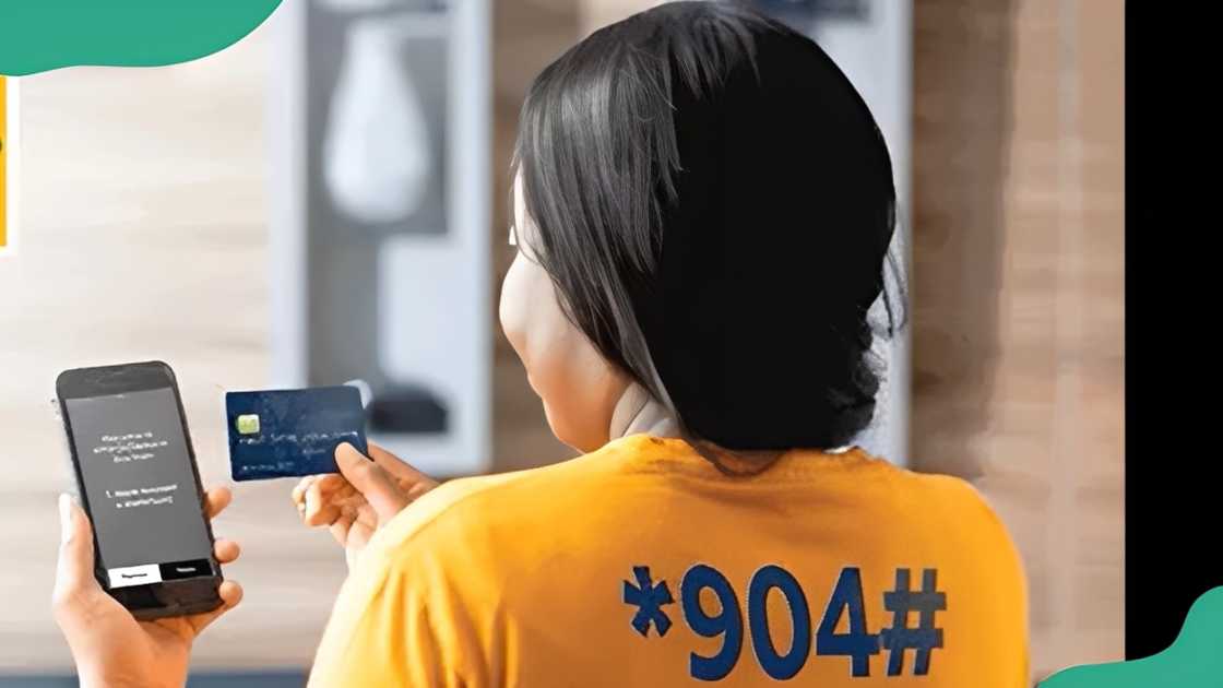 A woman using her phone and card for a banking USSD. A woman using her phone and card for a banking USSD.