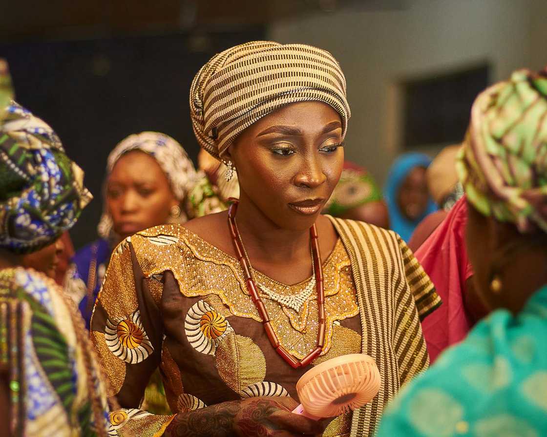Women in traditional attire attend a gathering.