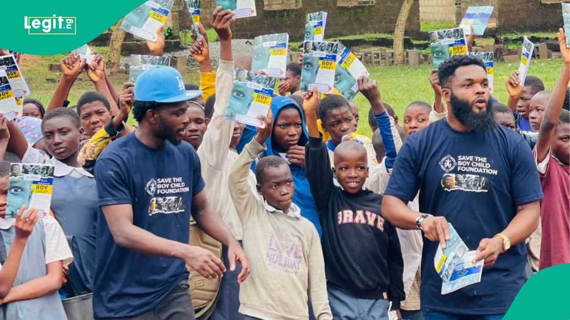 Young boys in school uniforms hold books donated by the Save the Boy Child Foundation. Young boys in school uniforms hold books donated by the Save the Boy Child Foundation.