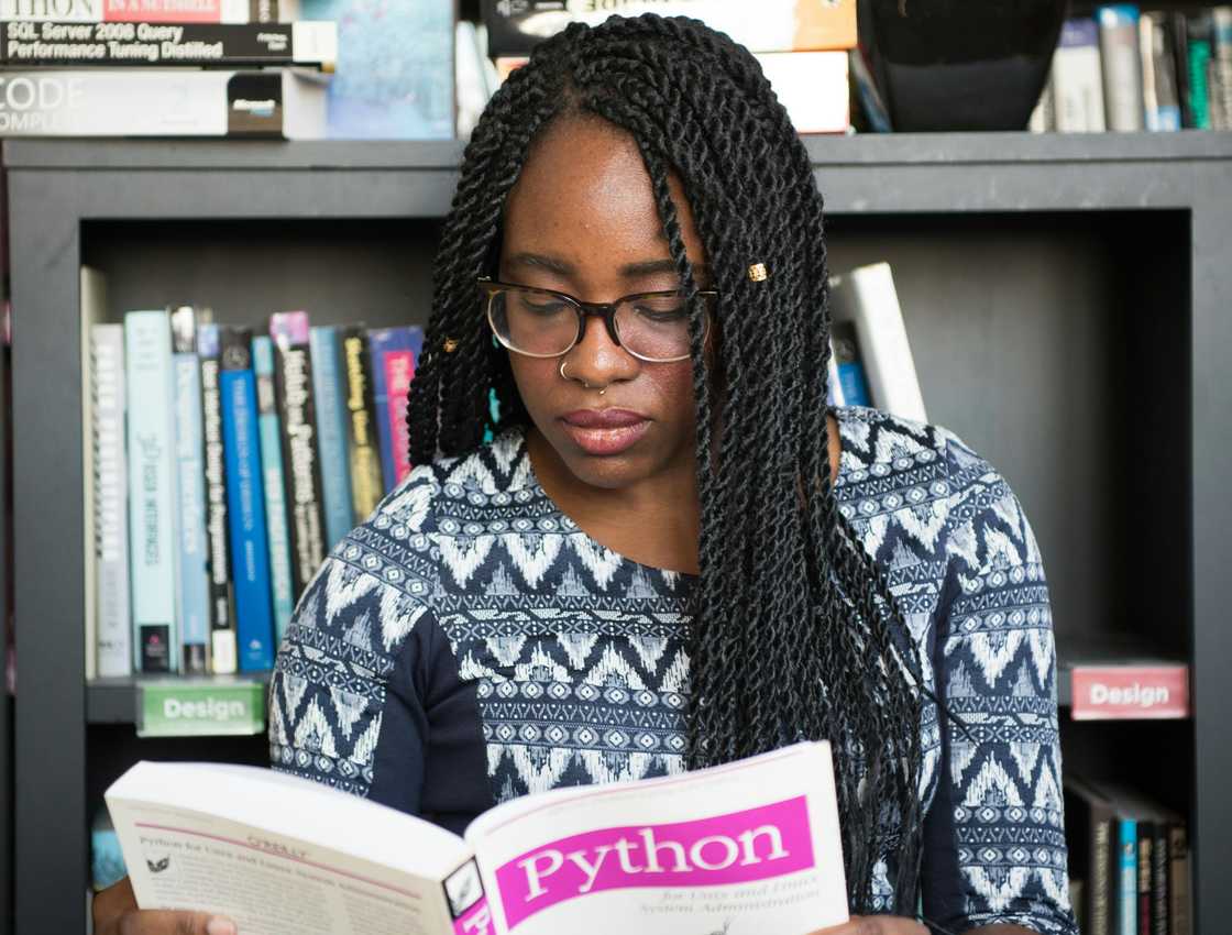 A lady reading a book in a library