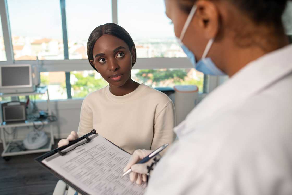 A lady receives her test report from a doctor