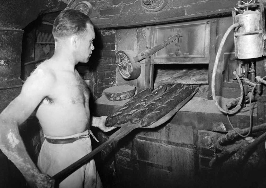A baker pulls a baguette from the oven in 1947. A baker pulls a baguette from the oven in 1947.
