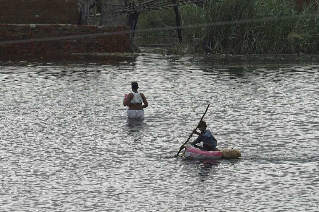 A child makes his way on a makeshift raft across flooded farmland near Sukkur, Sindh province A child makes his way on a makeshift raft across flooded farmland near Sukkur, Sindh province