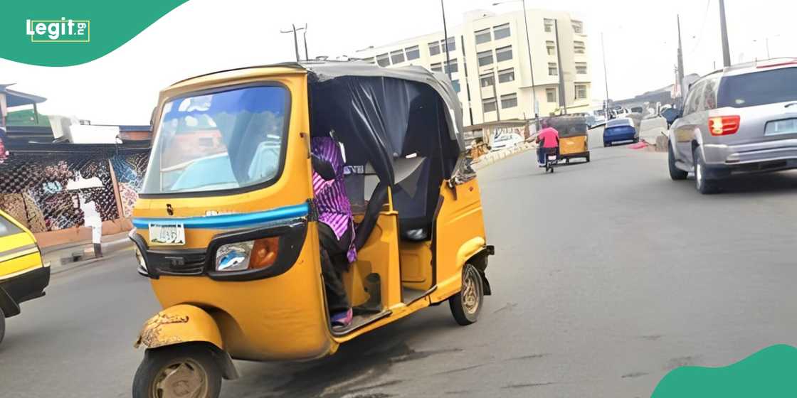 Woman passes on inside a Keke Marwa in Lagos