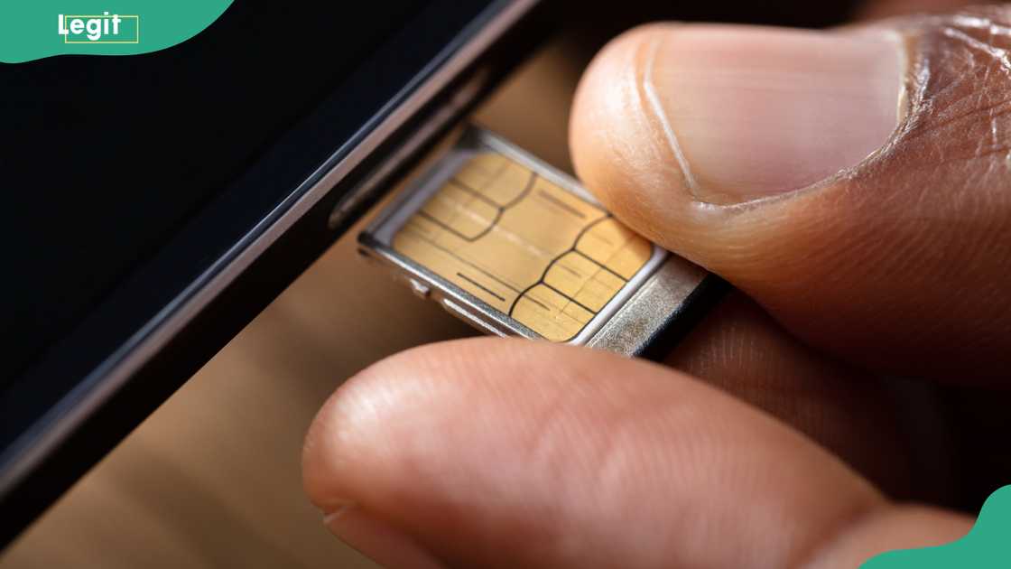 Person inserting a SIM card in a cellphone Person inserting a SIM card in a cellphone