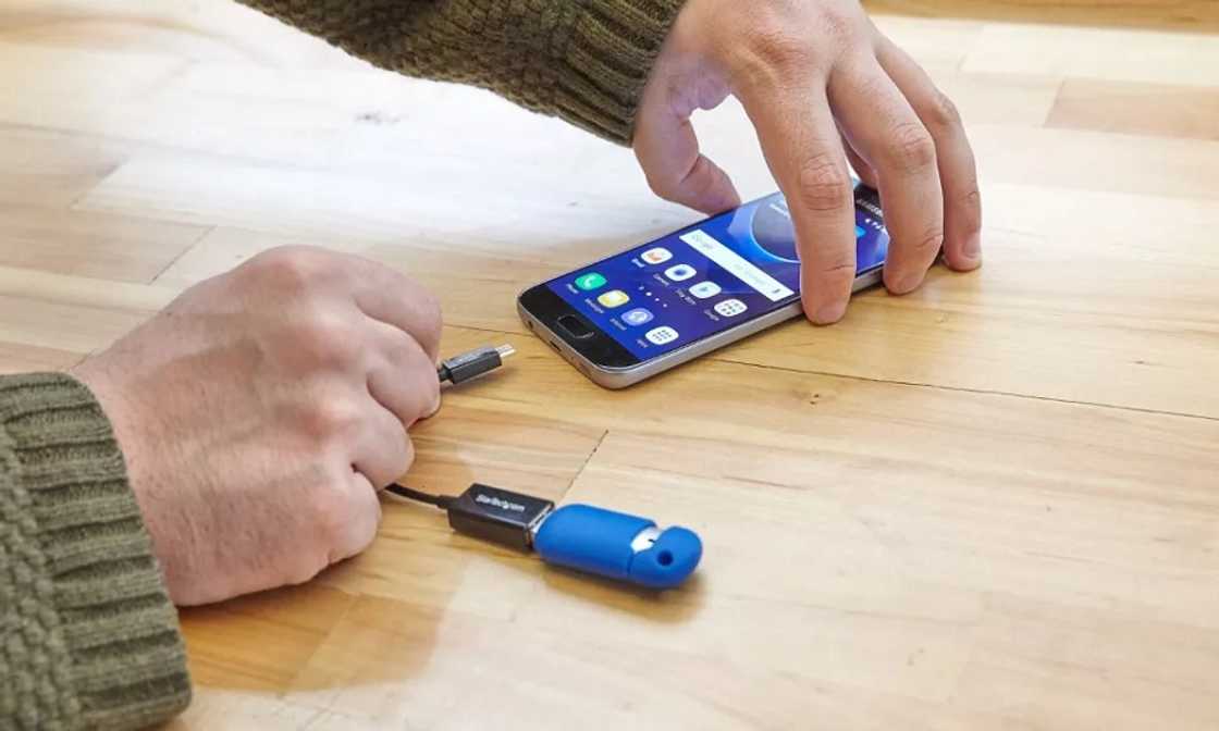 A person enabling an OTG with a smartphone. A person enabling an OTG with a smartphone.