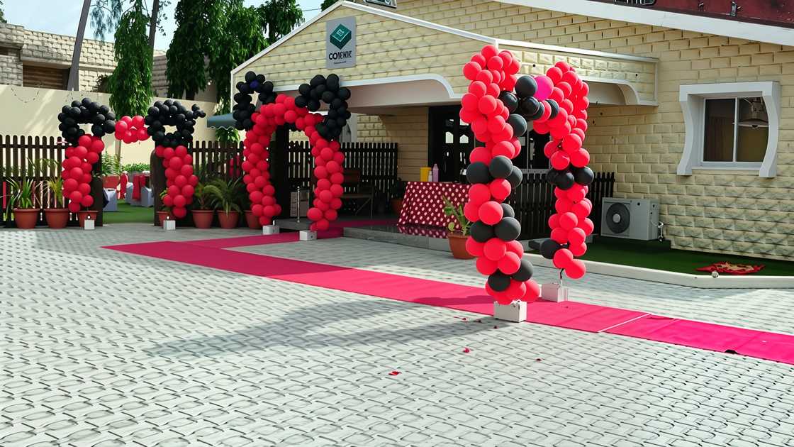 Red and black balloons and a red carpet adorn the entrance at Corner Indian Grill