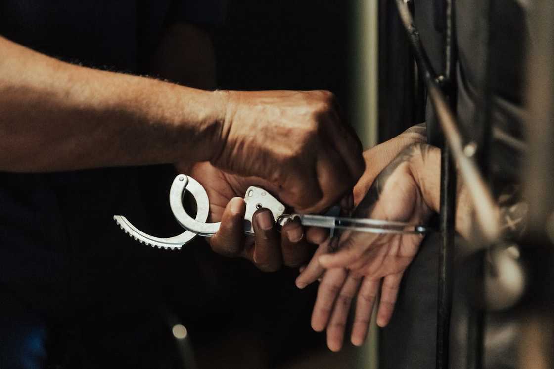 An officer removes handcuffs from someone’s wrists. An officer removes handcuffs from someone’s wrists.