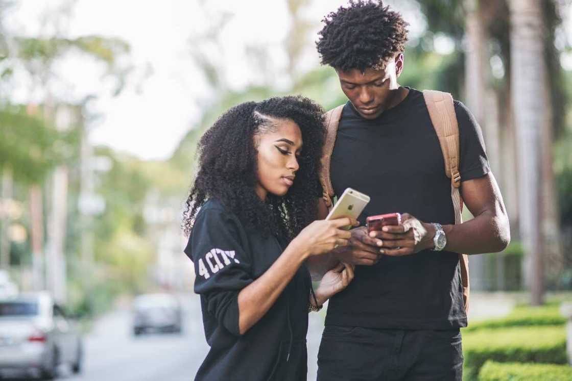 A man and a woman are checking their phones. A man and a woman are checking their phones.