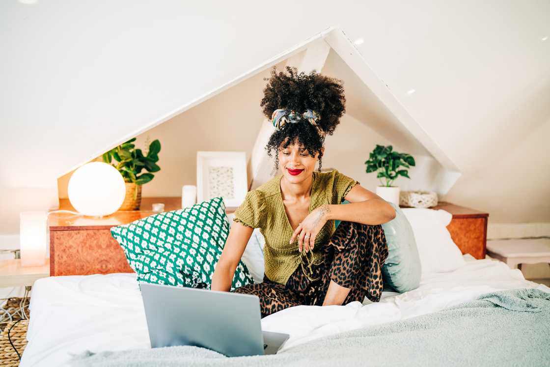A woman on a video call while sitting on a bed