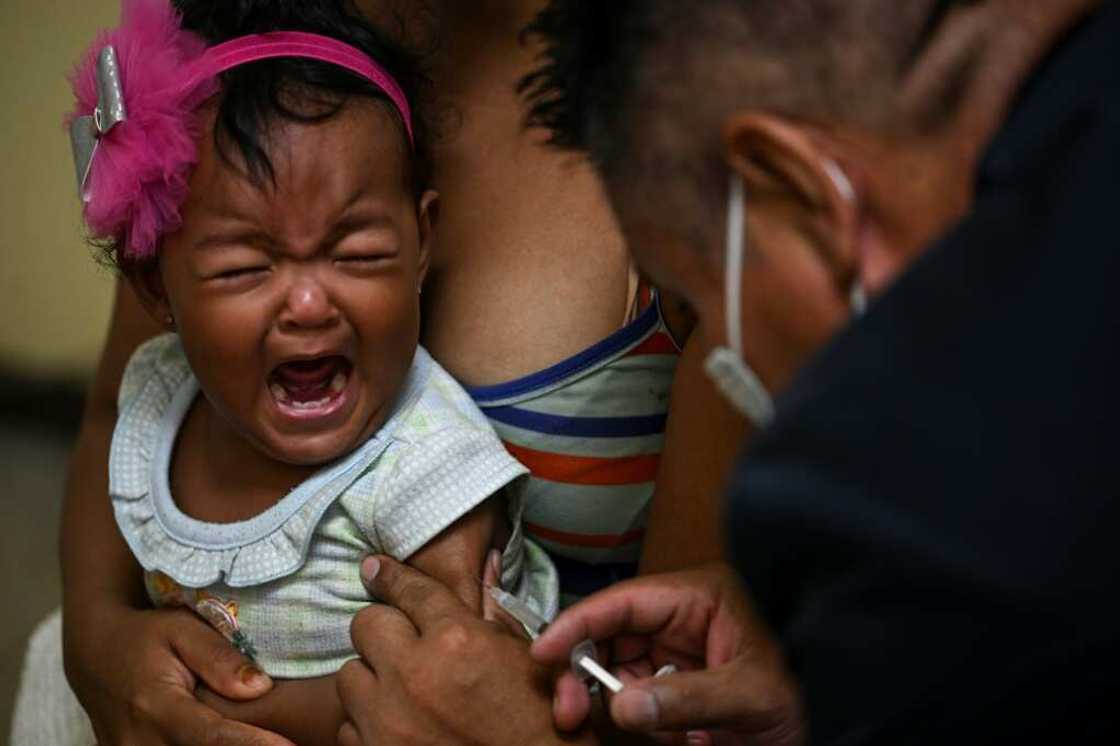 A girl accompanied by her mother receives a dose of measles and rubella vaccine from medical personnel at a community health center in the Lidice neighborhood in Caracas A girl accompanied by her mother receives a dose of measles and rubella vaccine from medical personnel at a community health center in the Lidice neighborhood in Caracas