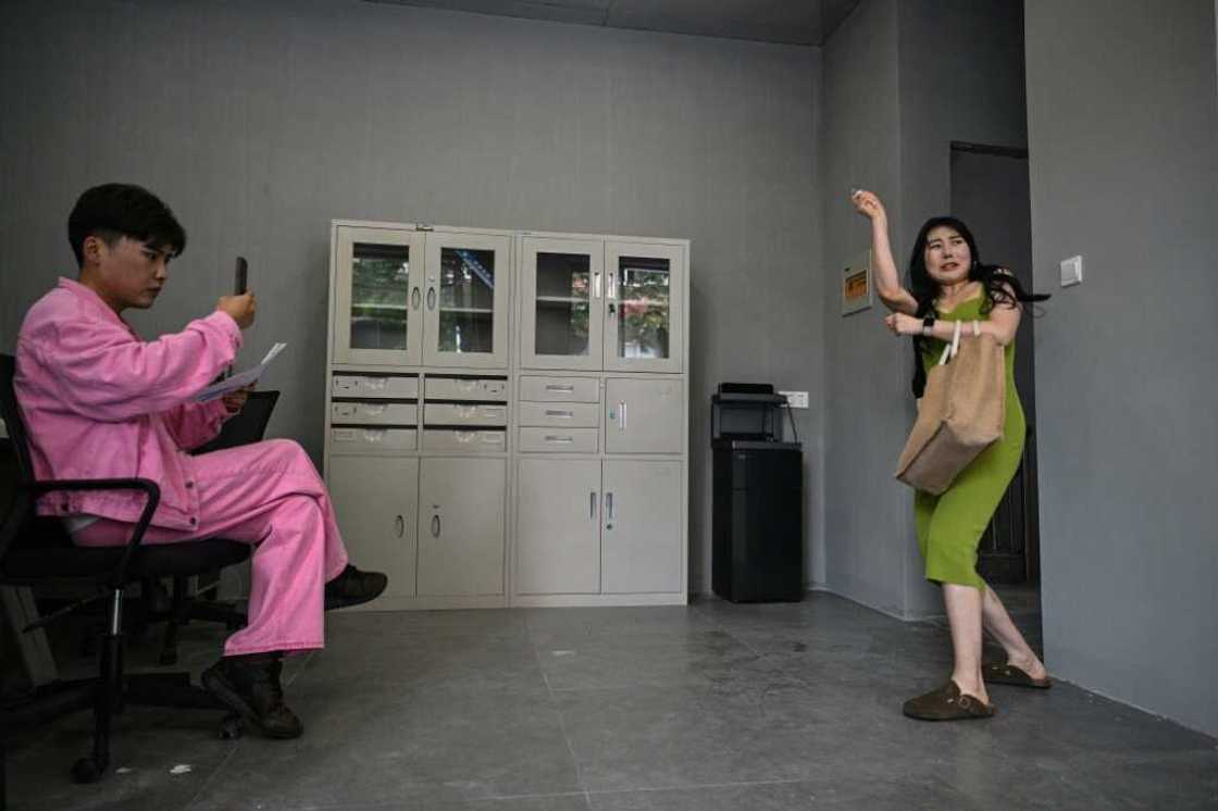 Former white-collar worker Guo Ting (R) performs during an audition for an acting role