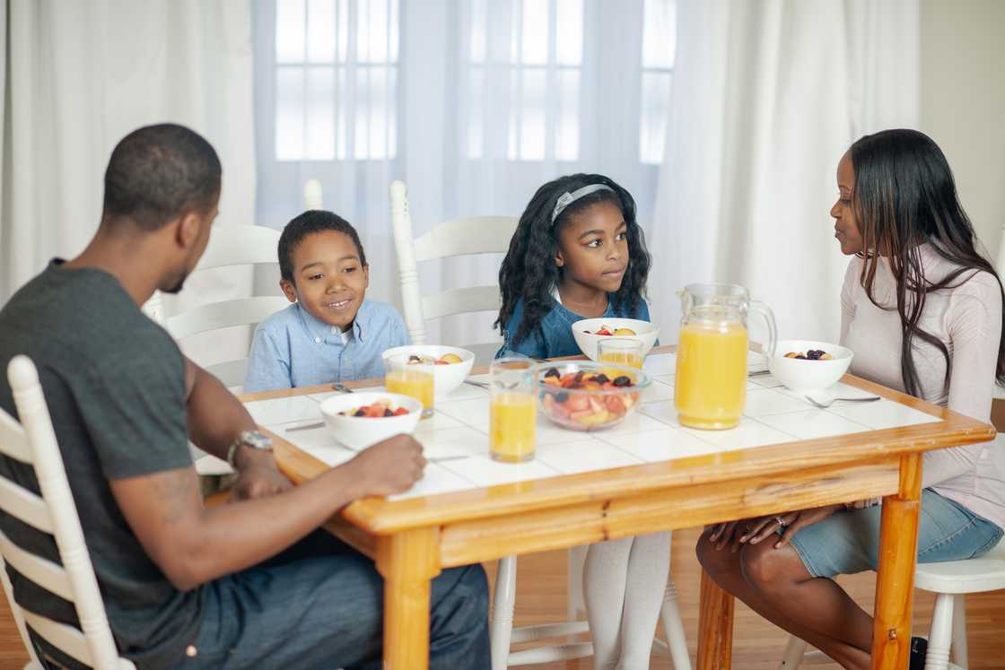 A family gathers at the breakfast table for a discussion.
