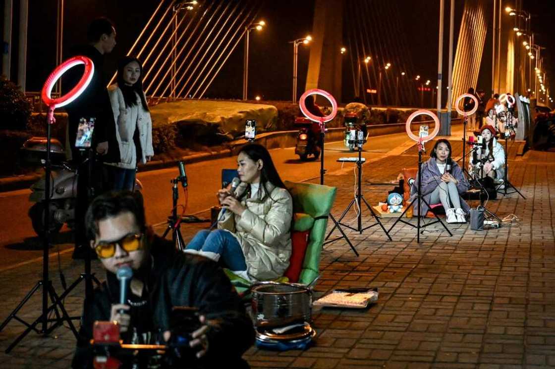Outdoor livestreamers sing and chat with their online audiences on a bridge in Guilin Outdoor livestreamers sing and chat with their online audiences on a bridge in Guilin