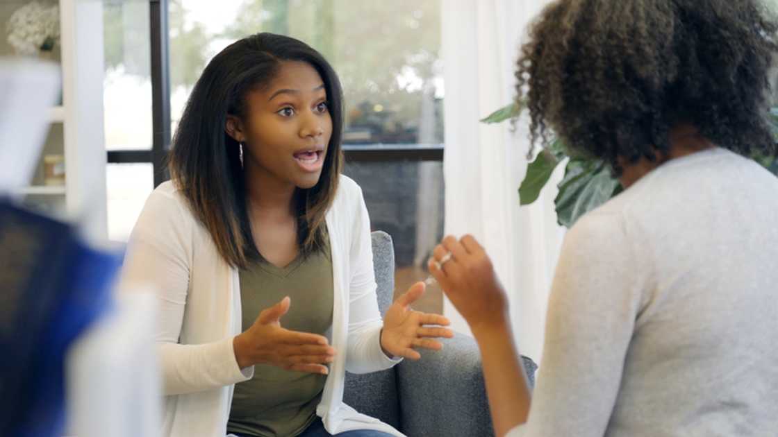 Two co-wives argue heatedly during a will reading.