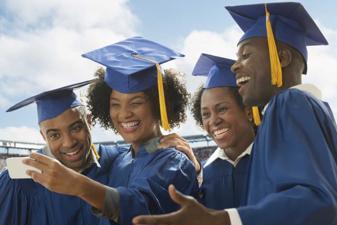 Students taking cell phone selfie at graduation Students taking cell phone selfie at graduation