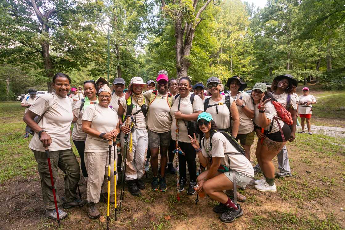 A large group of women hikers out in the campground ready to hike