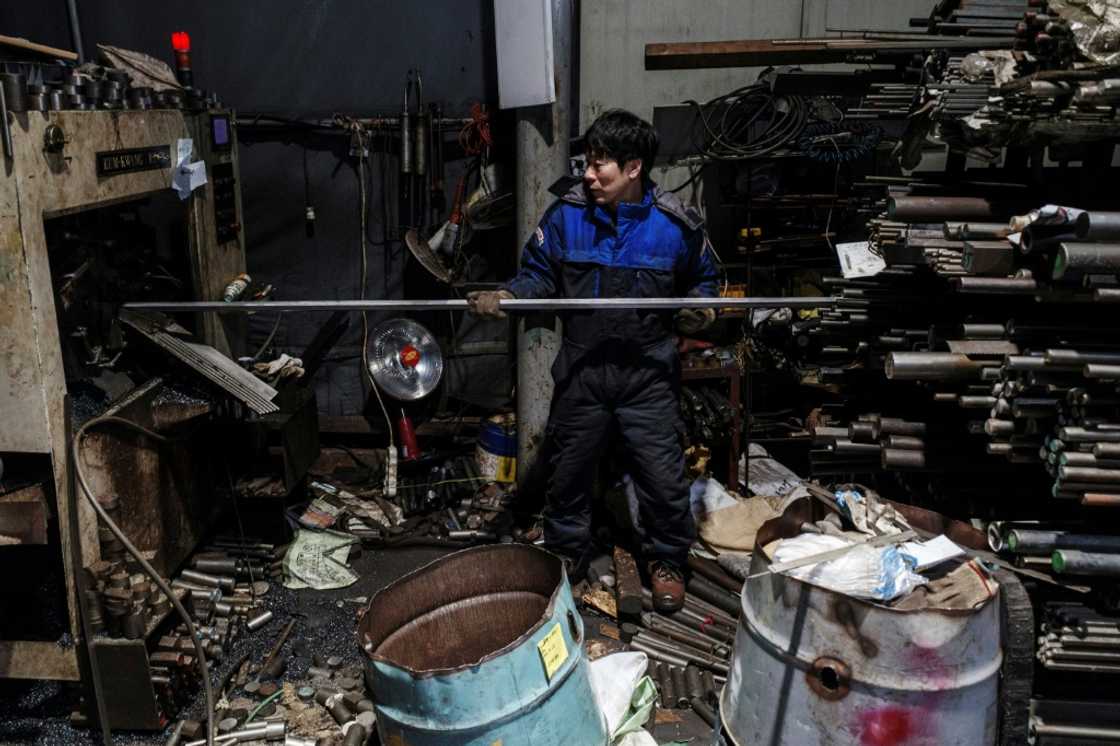 An employee works with steel as he operates machinery at a metal fabrication plant in Seoul