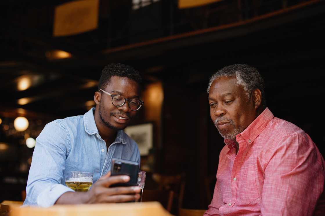 Two people sit at a table in a dimly lit café.