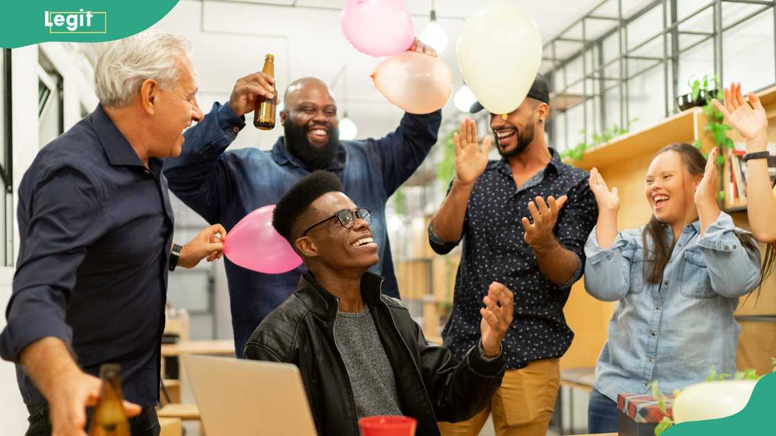 Business colleagues on a surprise work anniversary party at modern startup company