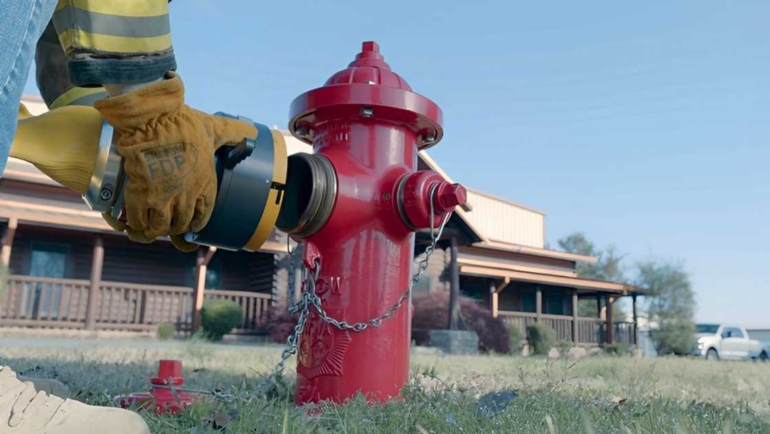 A firefighter demonstrates how to use the Hy-Conn hose adapter