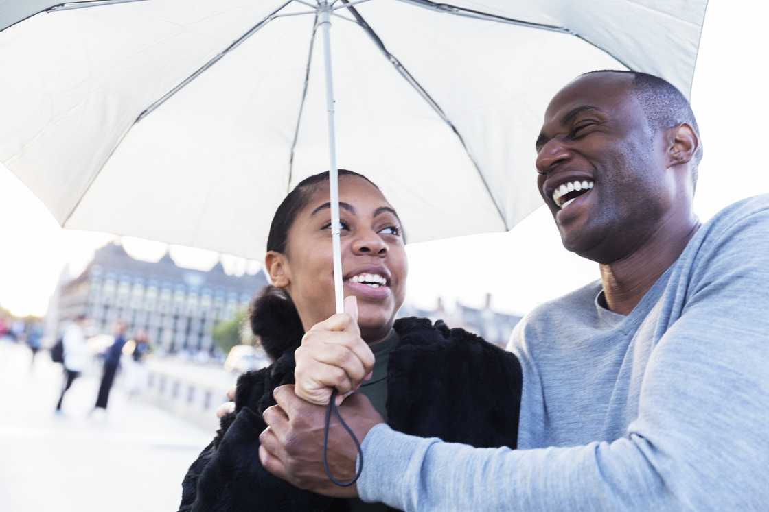A couple sharing an umbrella