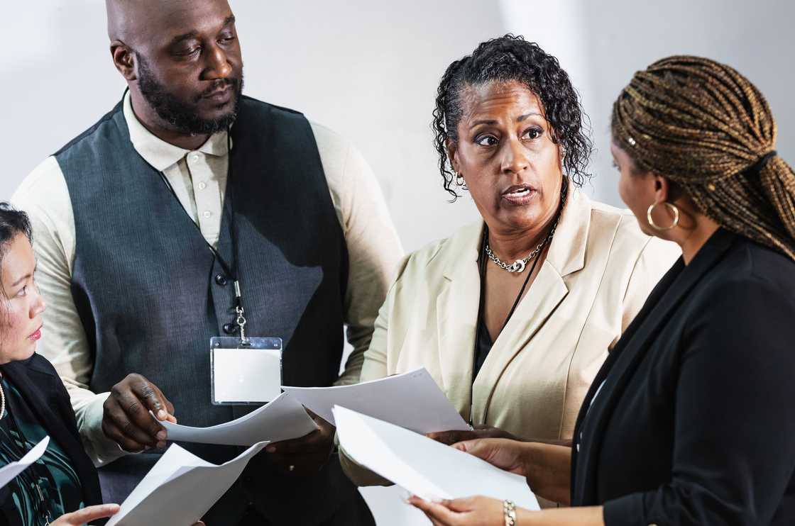 A lawyer tries to calm two arguing women during a will reading.